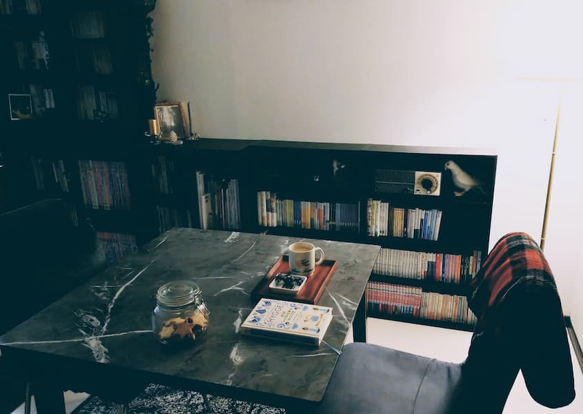 食卓の上にミルクティーとチョコレート、椅子にブランケット